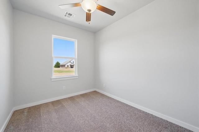 carpeted spare room featuring baseboards, a ceiling fan, and visible vents