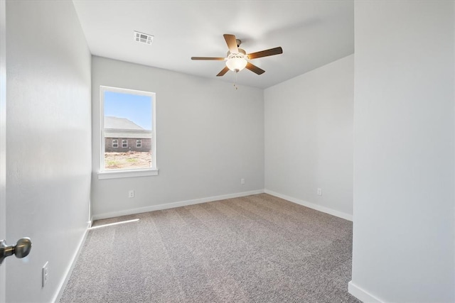 spare room with a ceiling fan, baseboards, and carpet