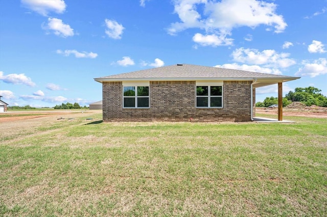 view of side of property with a yard and brick siding