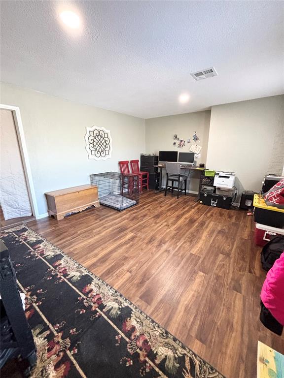9737 NE State Highway 15, Shattuck, OK 32911 - recreation room featuring visible vents, wood finished floors, and a textured ceiling