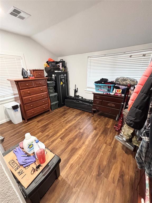 9737 NE State Highway 15, Shattuck, OK 32911 - bedroom featuring wood finished floors, lofted ceiling, and visible vents