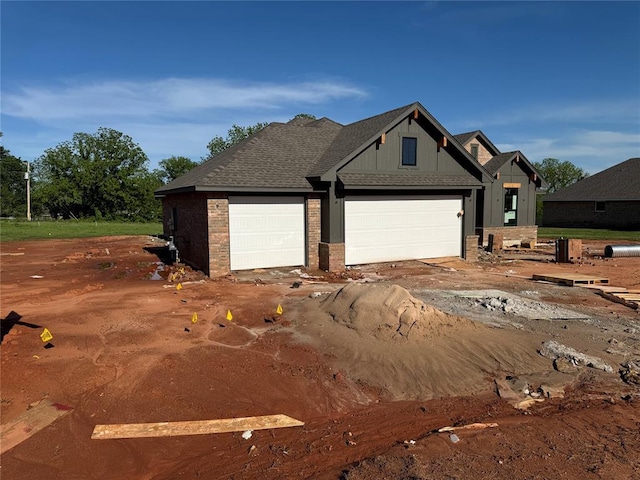 view of front facade featuring brick siding, a garage, and board and batten siding