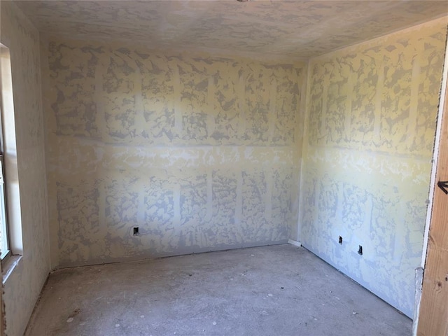 unfurnished room with concrete flooring