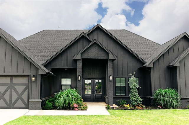 11813 NW 108th Pl, Yukon, OK 73099 - property entrance with french doors, board and batten siding, a garage, a yard, and a shingled roof