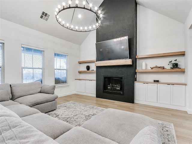 11813 NW 108th Pl, Yukon, OK 73099 - living area featuring high vaulted ceiling, a chandelier, light wood-style flooring, a large fireplace, and baseboards
