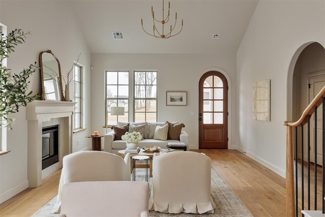 living area featuring a fireplace, visible vents, and light wood-style flooring