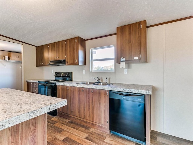 kitchen featuring a sink, under cabinet range hood, light countertops, and black appliances
