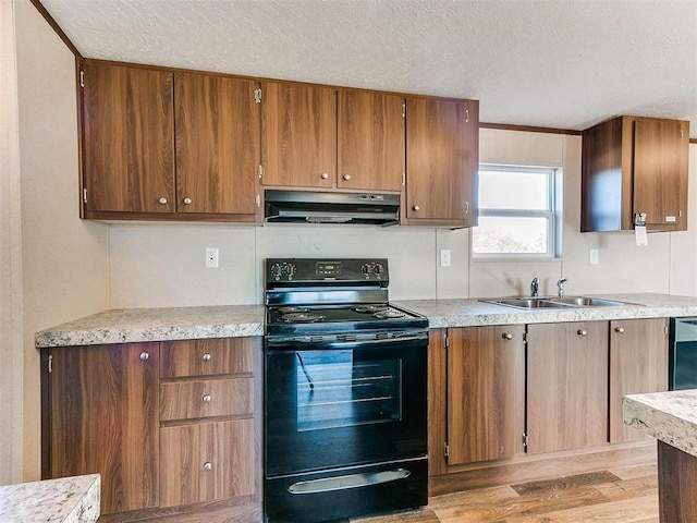 kitchen featuring light countertops, a sink, a textured ceiling, under cabinet range hood, and black electric range