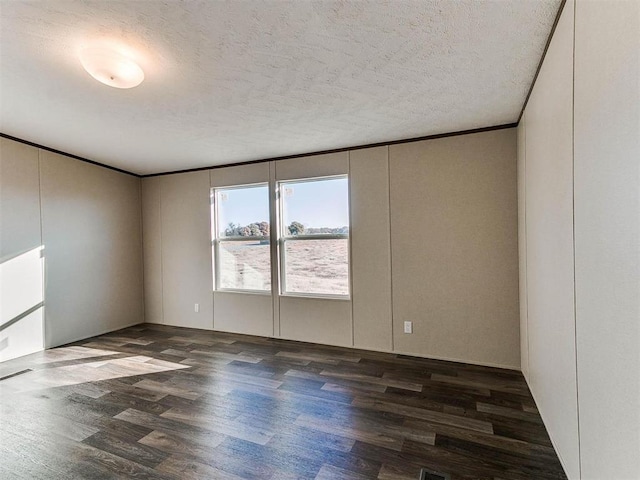 unfurnished room featuring a textured ceiling, visible vents, ornamental molding, and wood finished floors
