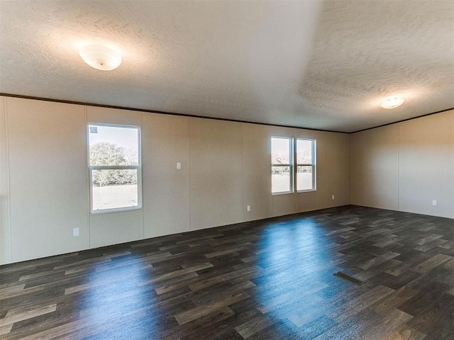 spare room with ornamental molding, a textured ceiling, and wood finished floors