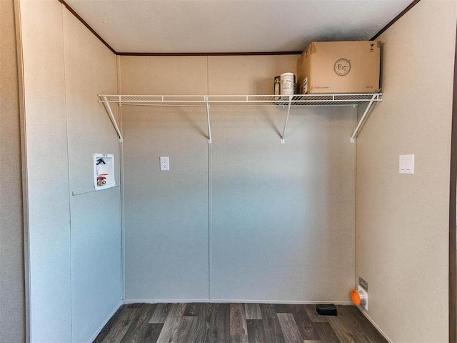 clothes washing area featuring dark wood finished floors, crown molding, laundry area, and washer hookup