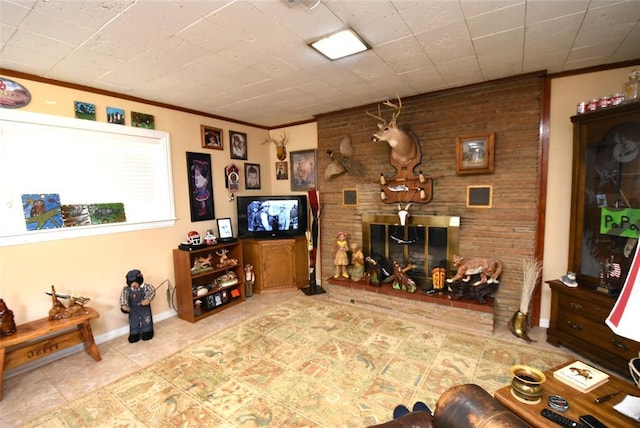 living area featuring baseboards, ornamental molding, a brick fireplace, and tile patterned flooring