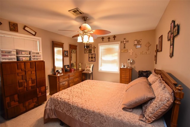 carpeted bedroom with ceiling fan and visible vents