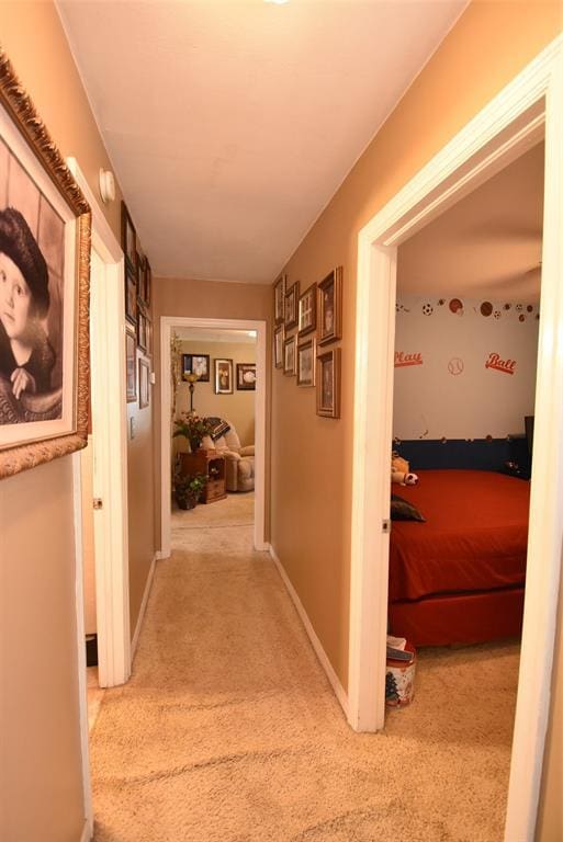 hallway with baseboards and carpet flooring