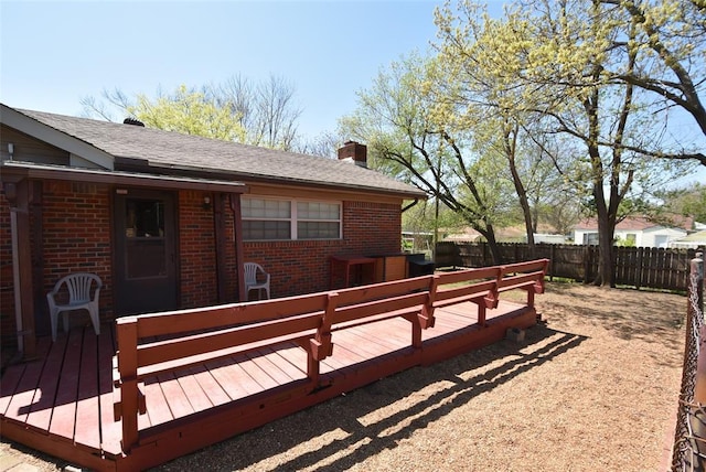 wooden terrace with a fenced backyard