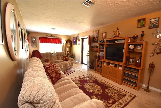living area featuring visible vents, a textured ceiling, baseboards, and carpet floors
