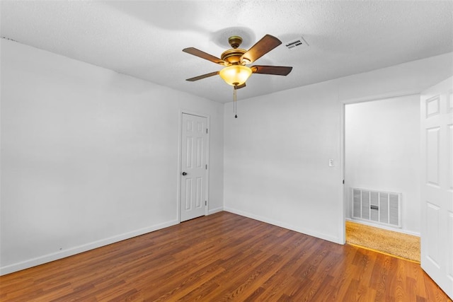 120 E 6th St, Stratford, OK 74872 - unfurnished room with visible vents, wood finished floors, ceiling fan, and a textured ceiling