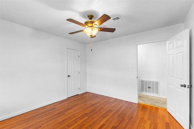 120 E 6th St, Stratford, OK 74872 - spare room with a textured ceiling, visible vents, a ceiling fan, and wood finished floors
