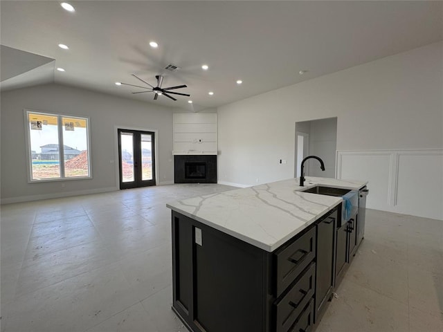 7120 NW 155th St, Edmond, OK 73013 - kitchen featuring a sink, a fireplace, dark cabinetry, a ceiling fan, and visible vents