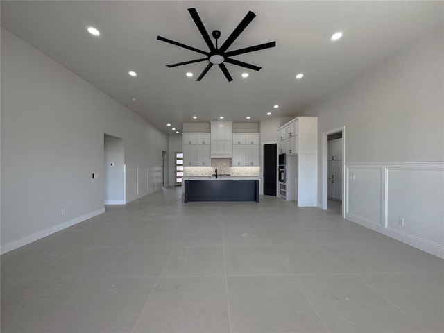 7120 NW 155th St, Edmond, OK 73013 - unfurnished living room featuring a ceiling fan, a sink, a decorative wall, recessed lighting, and light tile patterned flooring