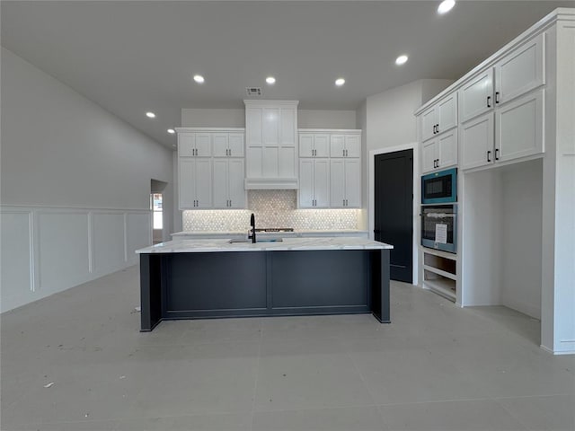 7120 NW 155th St, Edmond, OK 73013 - kitchen featuring built in microwave, stainless steel oven, tasteful backsplash, and white cabinetry
