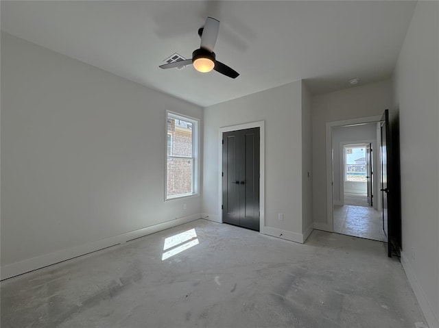 7120 NW 155th St, Edmond, OK 73013 - unfurnished bedroom featuring baseboards, concrete flooring, a closet, and multiple windows