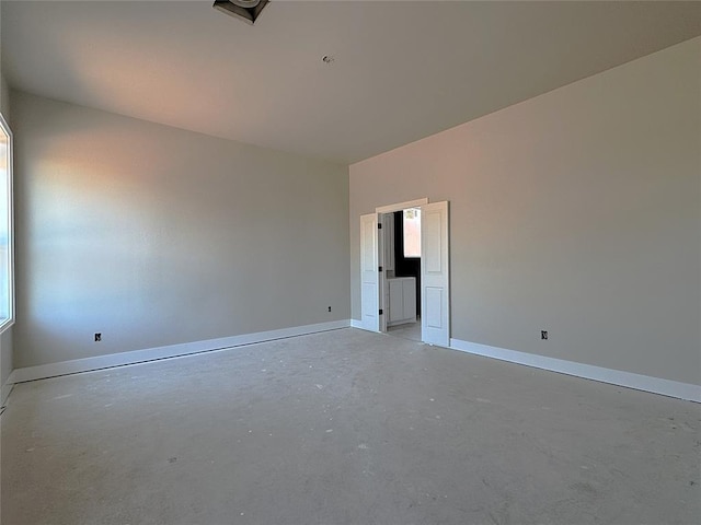 unfurnished room featuring baseboards and concrete floors