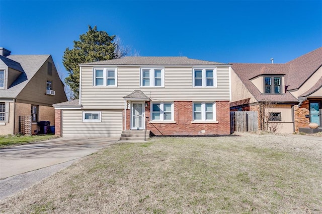 view of front of property with a front lawn, driveway, fence, and brick siding