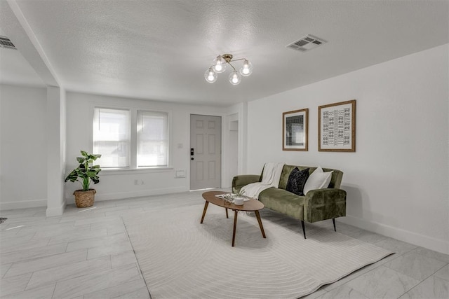 living area with marble finish floor, a textured ceiling, baseboards, and visible vents