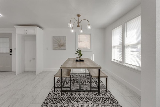 dining area featuring marble finish floor, baseboards, and a chandelier