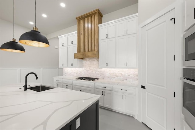 15600 Rockwell Park Ln, Edmond, OK 73013 - kitchen with stainless steel appliances, decorative backsplash, decorative light fixtures, white cabinets, and light stone countertops