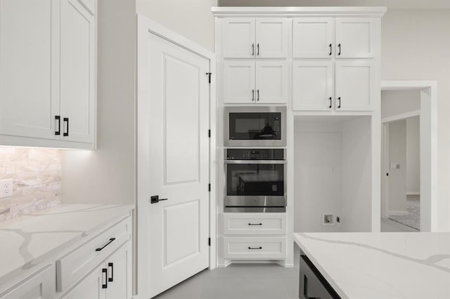 15600 Rockwell Park Ln, Edmond, OK 73013 - kitchen with stainless steel oven, built in microwave, white cabinets, and light stone countertops