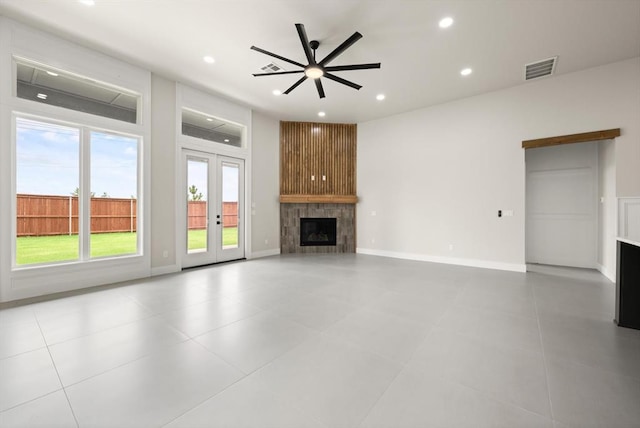 15600 Rockwell Park Ln, Edmond, OK 73013 - unfurnished living room featuring a large fireplace, ceiling fan, recessed lighting, french doors, and tile patterned flooring