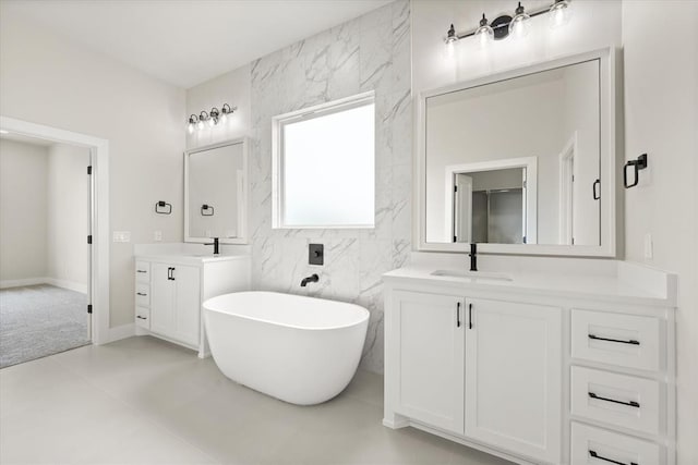 15600 Rockwell Park Ln, Edmond, OK 73013 - full bath featuring two vanities, a soaking tub, and tile walls