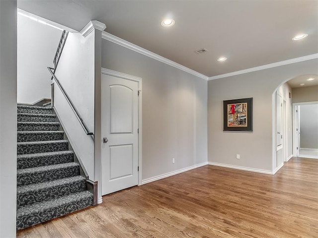 1109 Salvo Bridge Ct, Edmond, OK 73034 - stairway featuring arched walkways, ornamental molding, wood finished floors, and recessed lighting