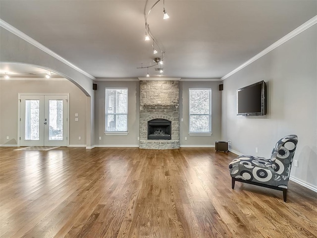 1109 Salvo Bridge Ct, Edmond, OK 73034 - living area with arched walkways, healthy amount of natural light, wood finished floors, and ornamental molding