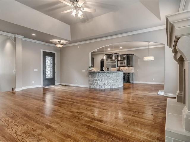 1109 Salvo Bridge Ct, Edmond, OK 73034 - unfurnished living room with arched walkways, a ceiling fan, ornamental molding, wood finished floors, and recessed lighting
