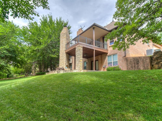 1109 Salvo Bridge Ct, Edmond, OK 73034 - back of property featuring a balcony, a lawn, a chimney, and stone siding