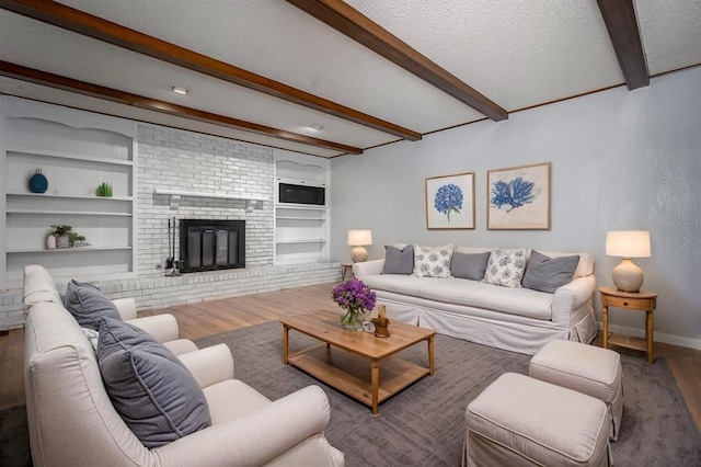 1527 N Pennsylvania Ave, Shawnee, OK 74804 - living room featuring wood finished floors, beam ceiling, built in shelves, a textured ceiling, and a fireplace