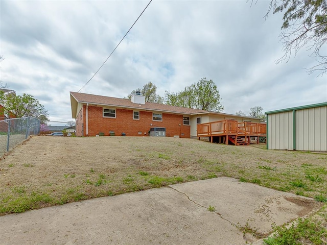 rear view of house featuring fence, a chimney, crawl space, a deck, and brick siding