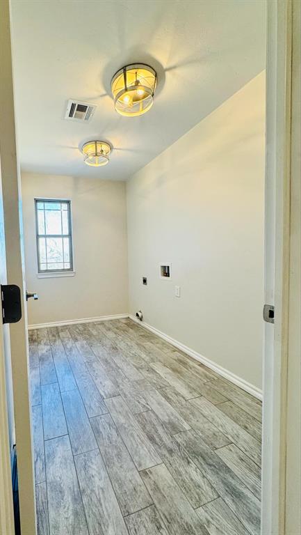 9514 N Woodchuck Ct, Edmond, OK 73034 - unfurnished room with baseboards, visible vents, and wood finished floors