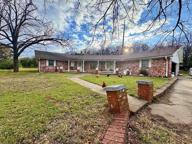 ranch-style home with a front yard, an attached garage, and brick siding