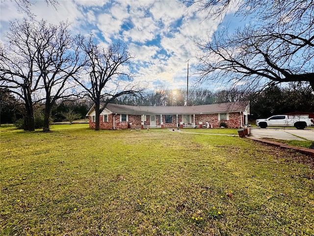 single story home featuring brick siding and a front yard