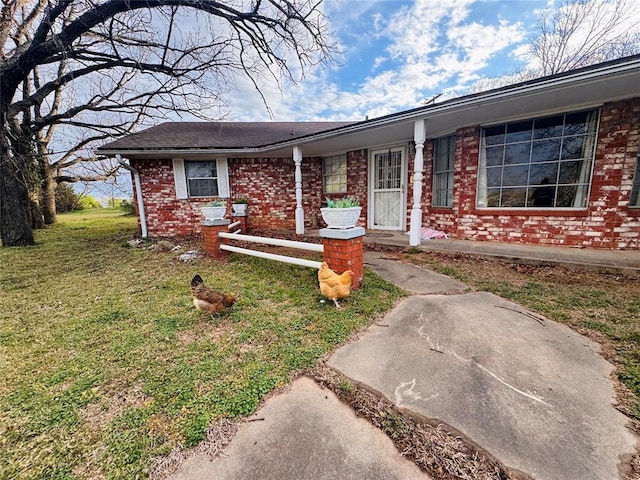 view of front of house featuring brick siding and a front lawn