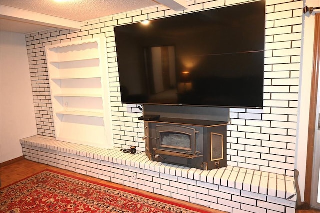details featuring beam ceiling, wood finished floors, a textured ceiling, built in features, and baseboards