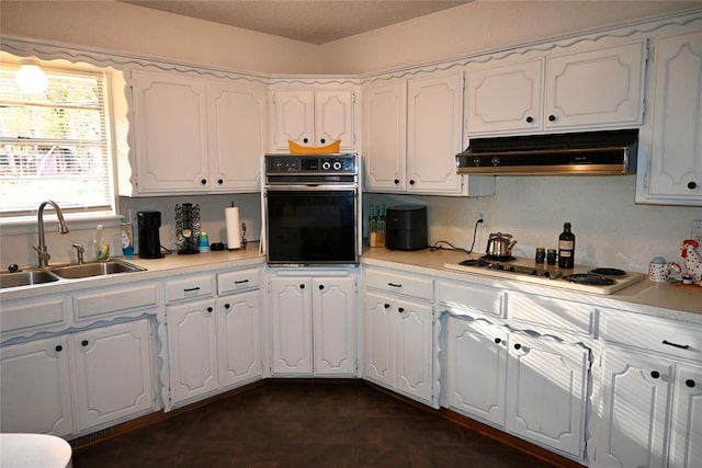 kitchen with white cabinetry, under cabinet range hood, a sink, and black oven