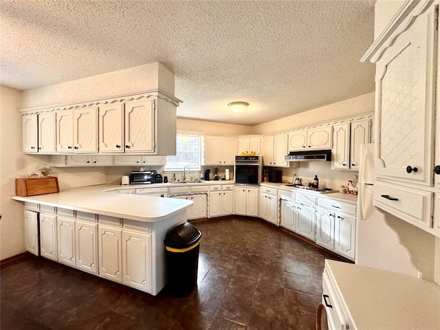 kitchen with light countertops, a peninsula, stovetop, under cabinet range hood, and black oven