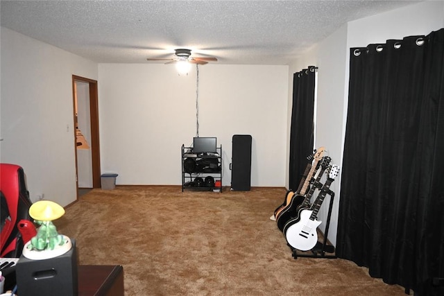 recreation room with a textured ceiling, a ceiling fan, and carpet