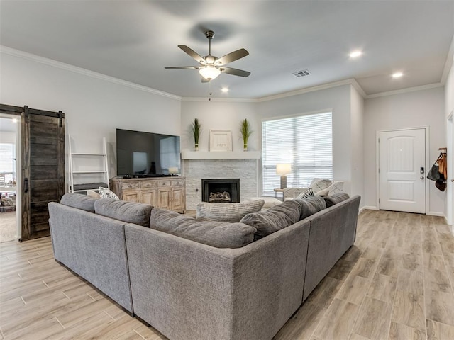 8512 NW 77th St, Oklahoma City, OK 73132 - living room featuring ornamental molding, light wood-style flooring, a barn door, visible vents, and ceiling fan