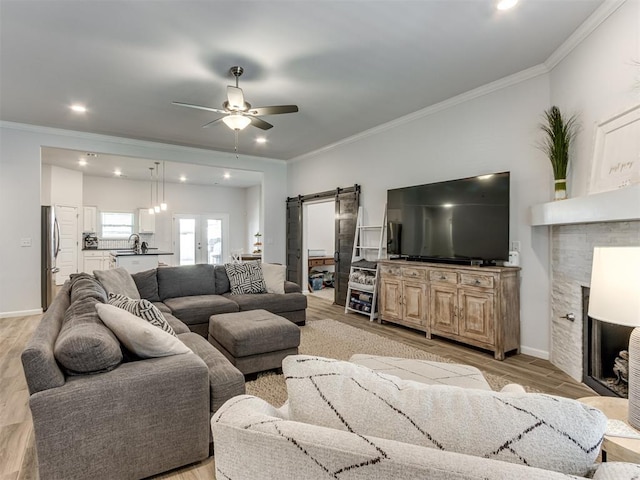 8512 NW 77th St, Oklahoma City, OK 73132 - living area with ornamental molding, ceiling fan, light wood-type flooring, and a barn door